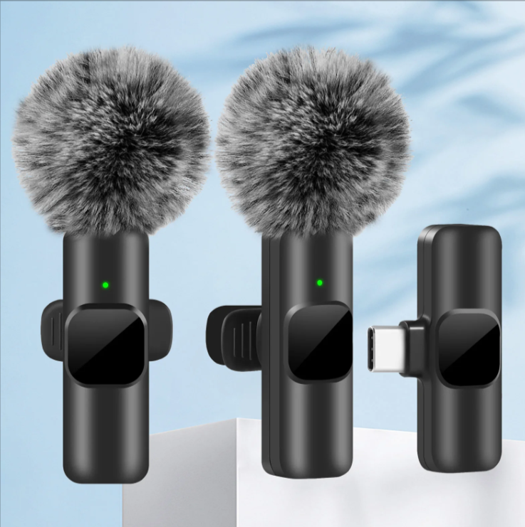 Two wireless lavalier microphones with attached USB-C and Lightning connectors, featuring gray fluffy windshields.